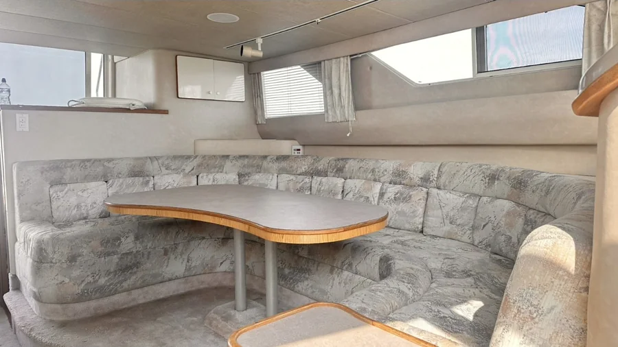 Salón comedor interior del Yate Premium, con sofá en U y mesa
